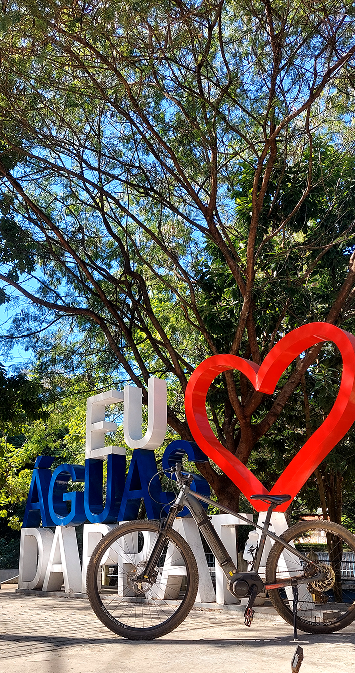 Bike elétrica em frente à placa de Eu Amo Aguás da Prata