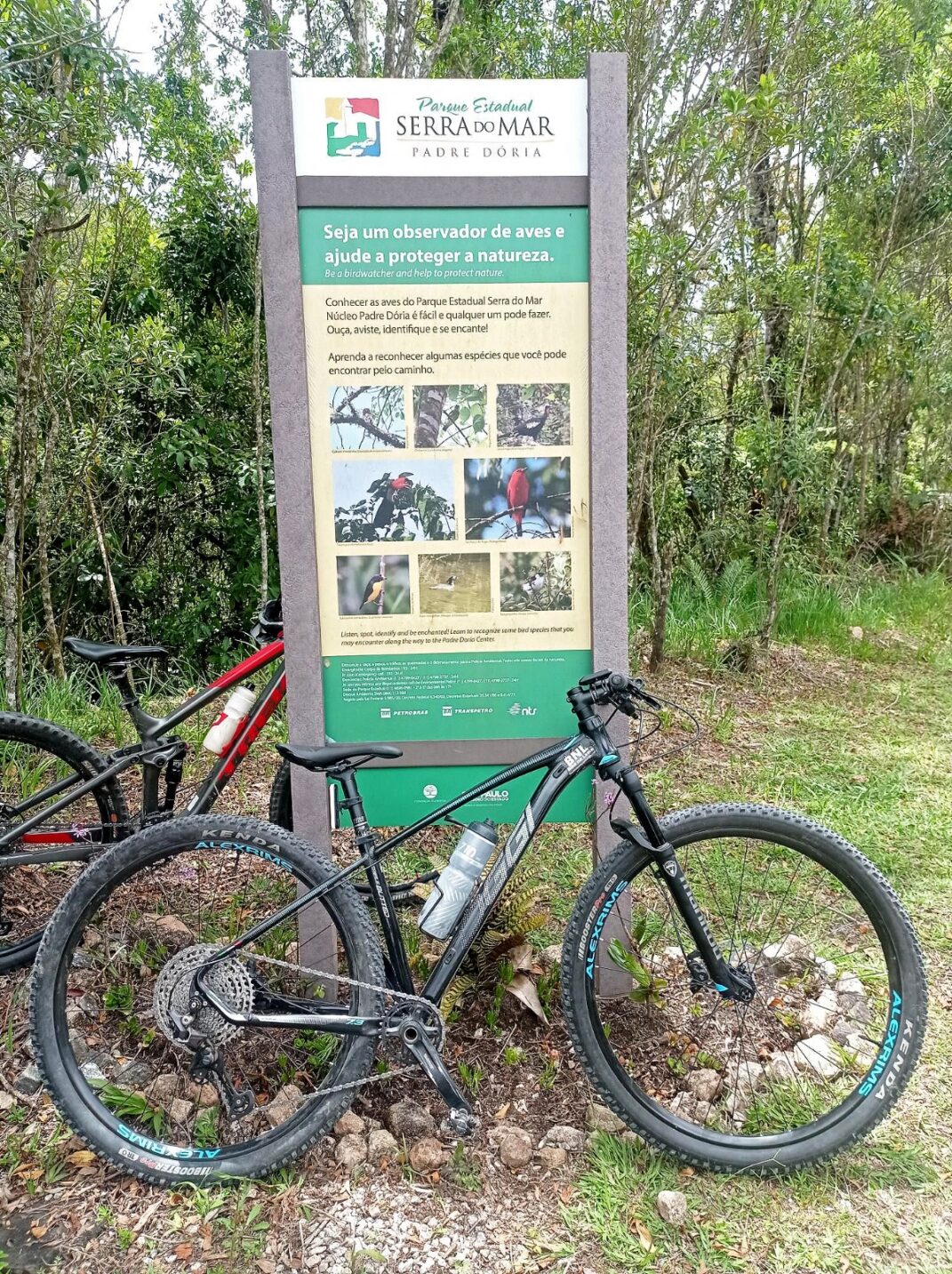 Bike encostada na placa ao ar livre em expedições de mountain bike ArAltos MTB