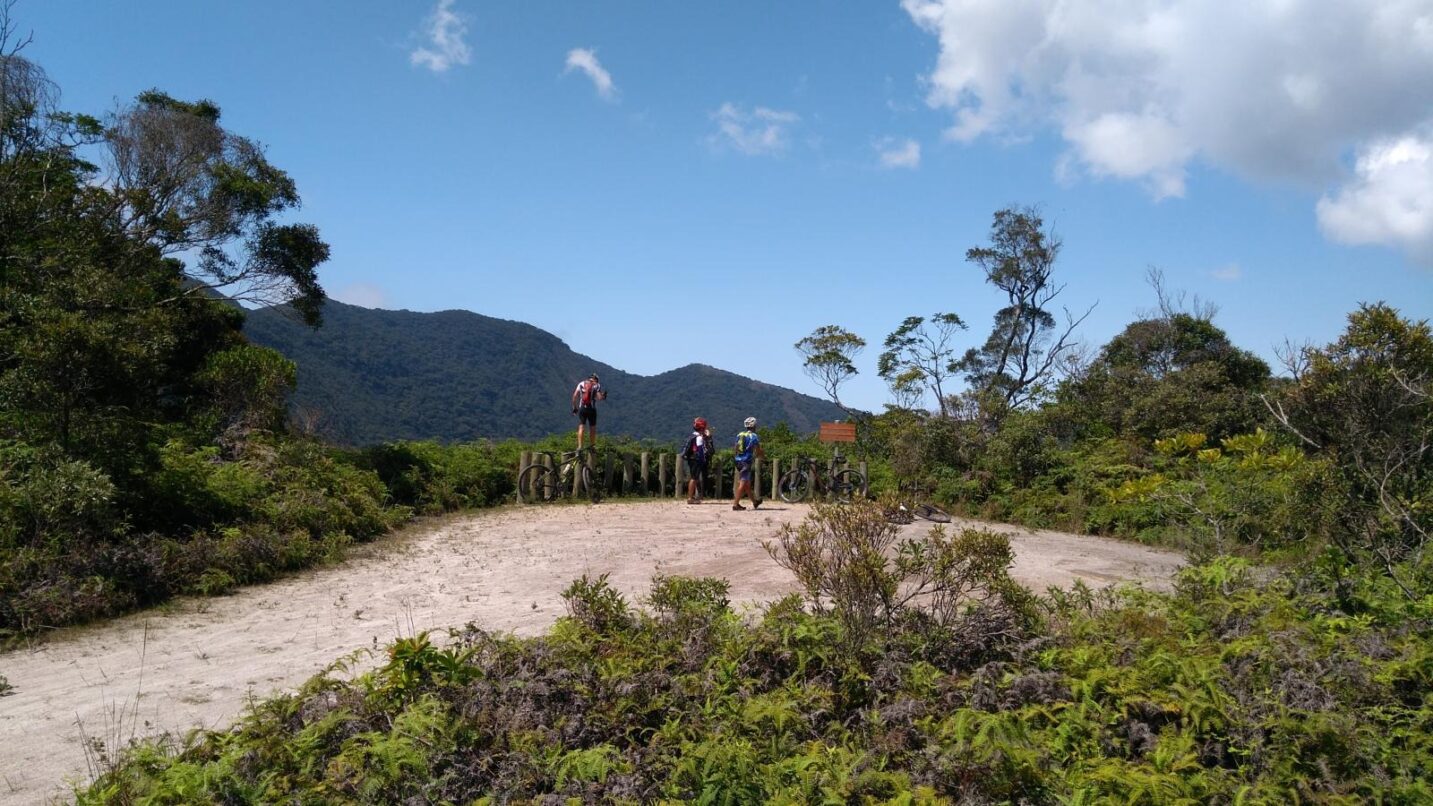 Ciclistas olham mirante em estrada de terra na Serra d o Mar