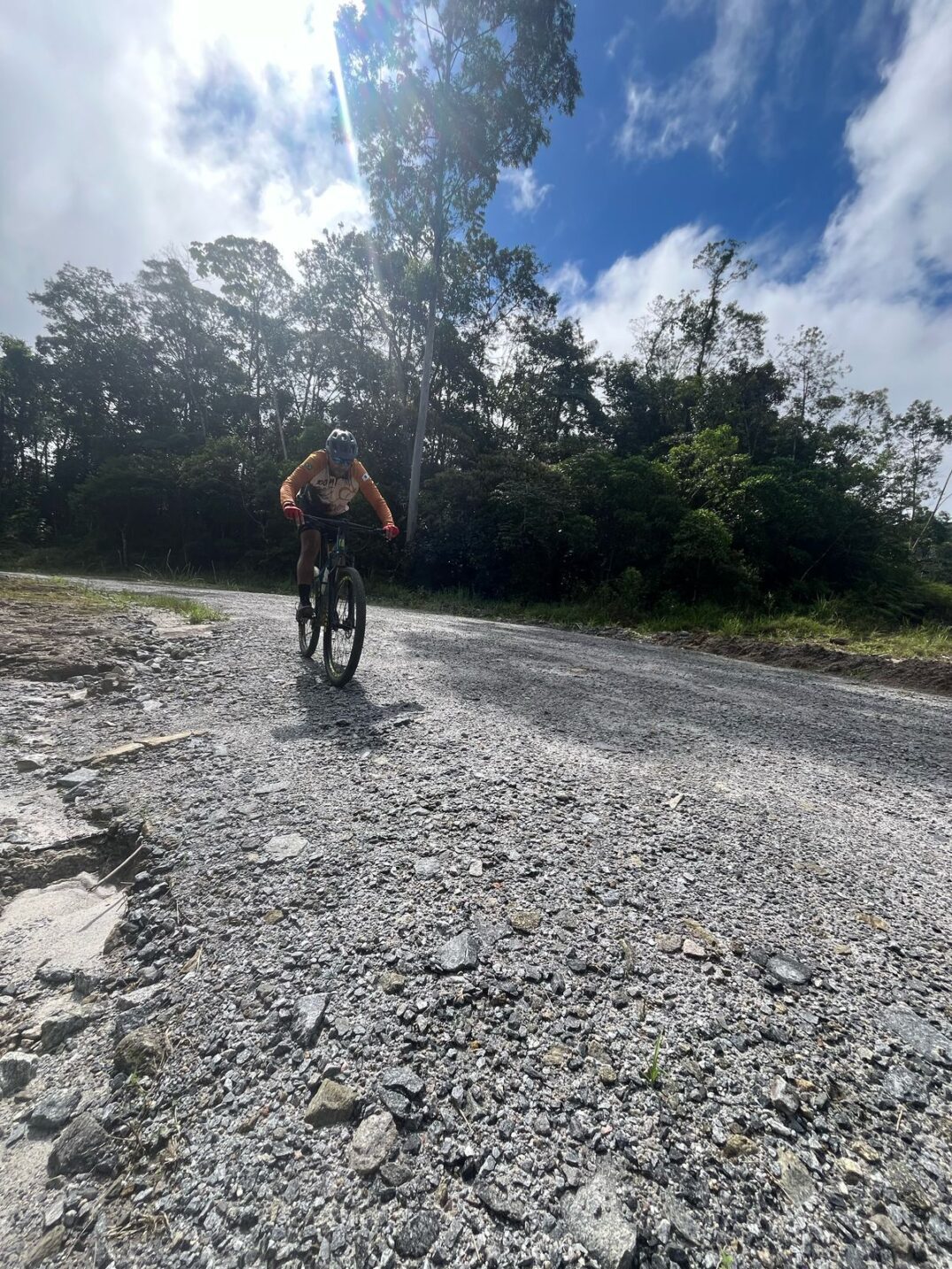 Ciclistas desce ladeira com estrada de pedra